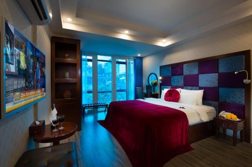 a bedroom with a large bed with a red blanket at Lavender Boutique House in Hanoi