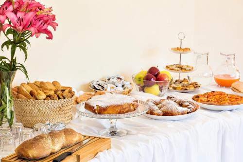 a table filled with bread and pastries and other foods at Hotel Terra degli Elimi in Buseto Palizzolo