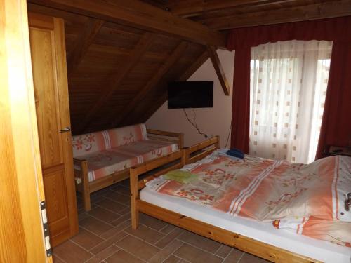 a bedroom with two beds and a flat screen tv at Napos Vendégház in Győr