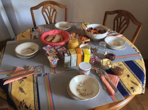 una mesa con platos y tazones de comida. en Le Petit Bijou en Saint-Fraigne
