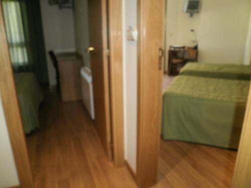 a room with two beds and a wooden floor at Hotel Costa Verde in Neaño