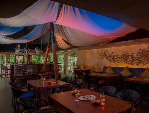 a restaurant with tables and chairs and a colorful ceiling at Radisson Blu Resort Temple Bay Mamallapuram in Mahabalipuram
