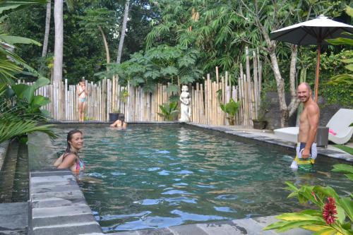 un grupo de personas de pie en una piscina en Suka's House Bed & Breakfast, en Ubud