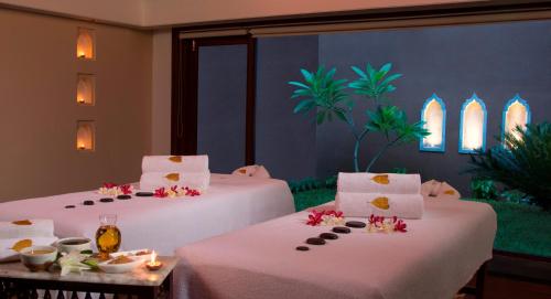 a room with two beds with food on them at Radisson Blu Resort Temple Bay Mamallapuram in Mahabalipuram