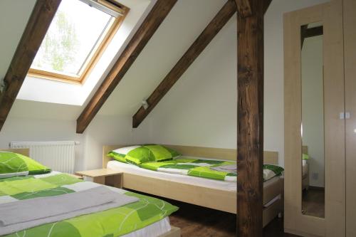 1 dormitorio con 2 camas y ventana en Penzion Na Pohoři en Olešnice