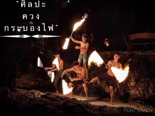 a group of young men holding fire torches at Sangthian Beach Resort in Ko Samed