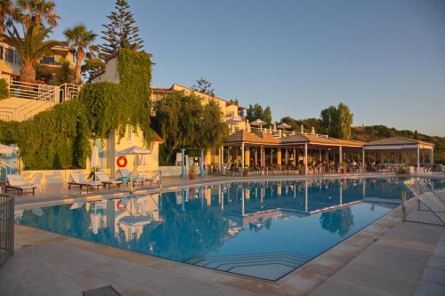 een groot zwembad met een hotel op de achtergrond bij Rethymno Mare & Water Park in Skaleta