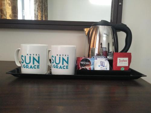 a shelf with three coffee mugs and a kettle at Hotel SunGrace in Mussoorie