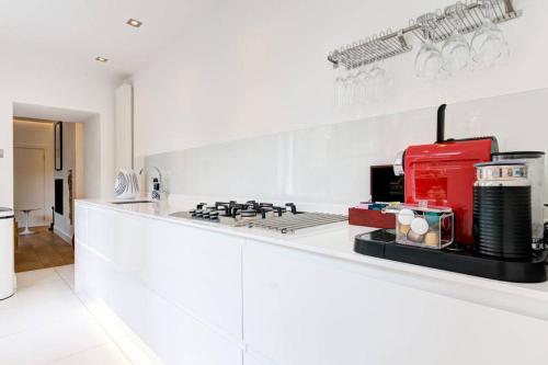 a white kitchen with a red appliance on a counter at The Greyfriars Apartment in St. Andrews