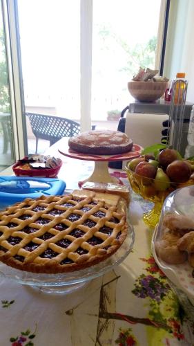 een tafel met een taart en andere voedingsmiddelen erop bij B&B Il Papavero Rosso in Corigliano dʼOtranto