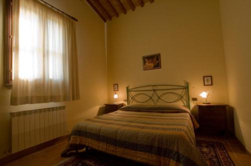una camera con un letto e una finestra e due lampade di Tenuta di Alberese ad Alberese