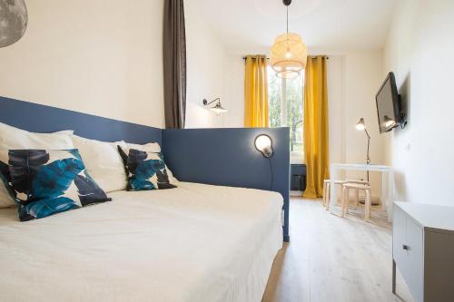 une chambre avec un grand lit et une tête de lit bleue dans l'établissement Studio Jardin des Plantes Lyon1er, à Lyon