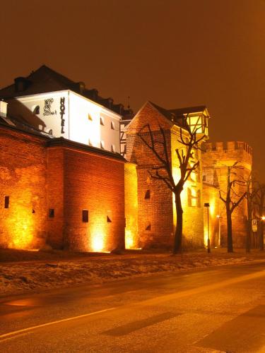 a large brick building with lights on it at night at Hotel Spichrz in Toruń