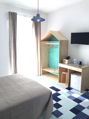 a bedroom with a bed and a desk with a television at Il Grande Blu in Terracina