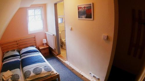 a small bedroom with a bed and a window at Horská chata Plzeňka Pernink in Pernink