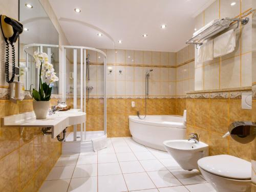 La salle de bains est pourvue d'une baignoire, d'un lavabo et de toilettes. dans l'établissement Hotel Boss, à Varsovie