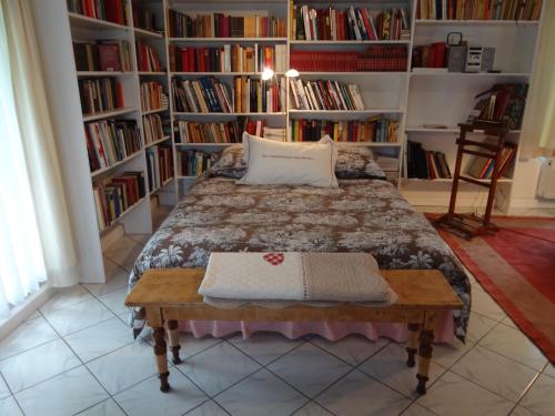 um quarto com uma cama e estantes de livros com livros em Château Mesny Gite Au Fil des Pages em Vic-sur-Seille