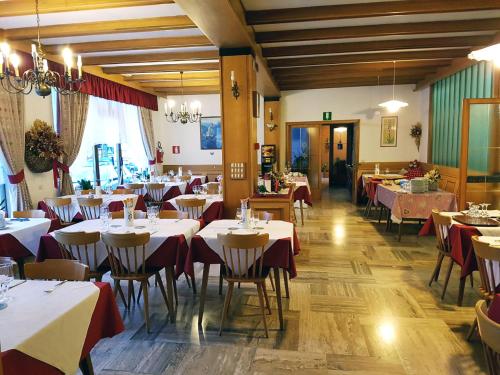 a restaurant with tables and chairs with red and white tablecloths at Albergo Posta in Colle Santa Lucia