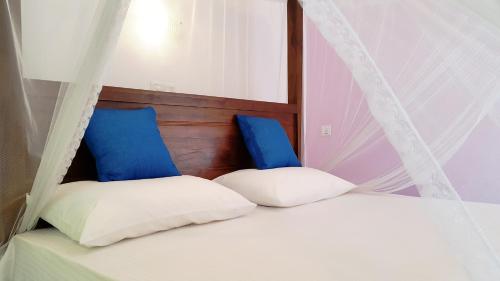 una camera con 2 letti con cuscini blu e bianchi di Moonlit Bay Weligama a Weligama