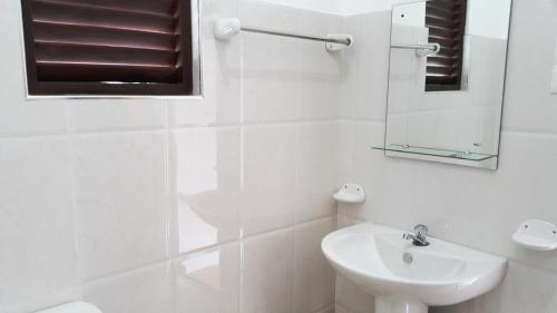 un bagno bianco con lavandino e specchio di Moonlit Bay Weligama a Weligama