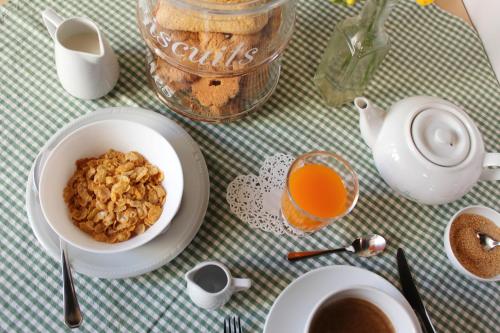 a table with a bowl of cereal and a cup of coffee at B&B Antica Biblioteca in Fermo