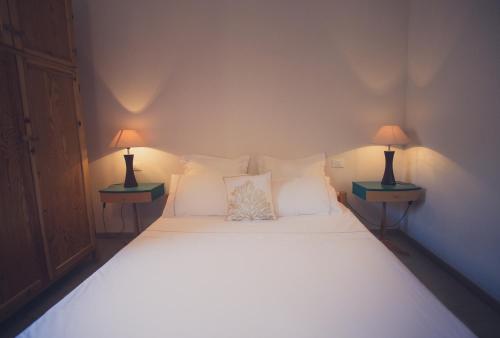 una camera da letto con un letto con due lampade su entrambi i lati di Carolina's Beach House a Geremèas