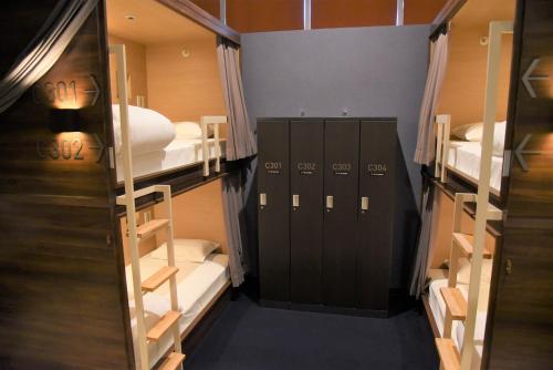 熊本市にあるHotel The Gate Kumamotoの二段ベッドとロッカーが備わる客室です。