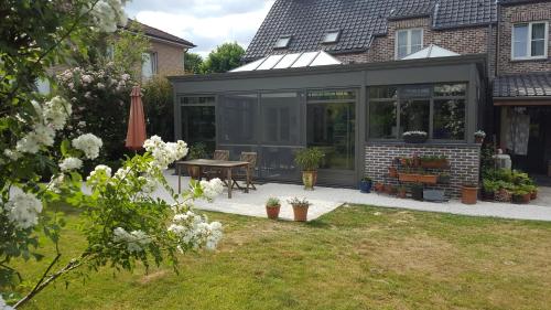 a glass extension of a house with a table at B&B La Clé du Sud in Merelbeke