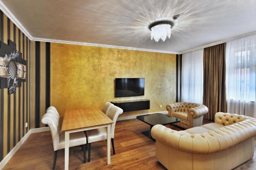 a living room with a couch and a table at Wellness Hotel Republika 24 Apartments in Plzeň