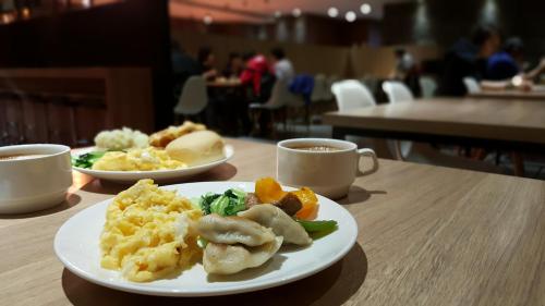 zwei Teller Essen auf einem Tisch mit Tassen Kaffee in der Unterkunft The Riverside Hotel International in Kaohsiung