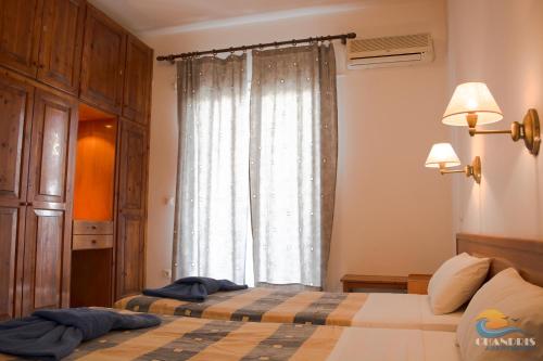 a bedroom with two beds and a window at Chandris Apartments in Kavos