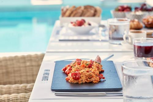a blue plate with a piece of food on a table at Mr and Mrs White Paros in Naousa