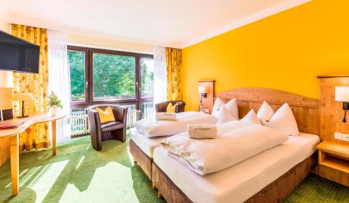 2 łóżka w pokoju z żółtymi ścianami w obiekcie Hotel Sonnenhof w mieście Bad Birnbach