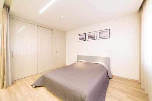 een slaapkamer met een bed in een witte kamer bij Benetis apartments in Klaipėda