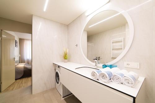 a bathroom with a sink and a mirror at Benetis apartments in Klaipėda