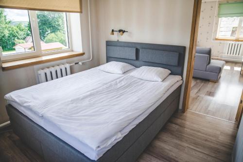 1 dormitorio con 1 cama grande con sábanas blancas en Beach Apartment, en Rõuge