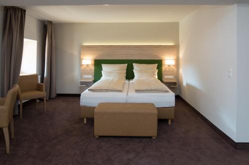 a hotel room with a bed and two chairs at SPIEGLHOF apart in Kumhausen