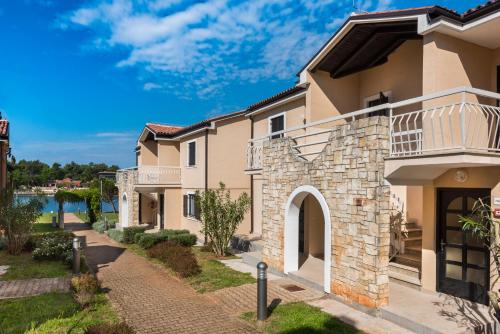 uma casa grande com uma passagem à frente em Apartments Amfora Plava Laguna em Umag