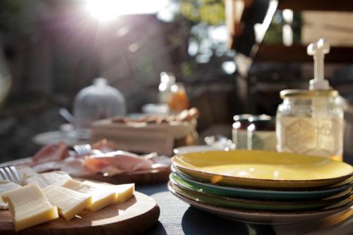 a table with a plate of cheese and plates of food at La casa di paglia B&B in Verrayes