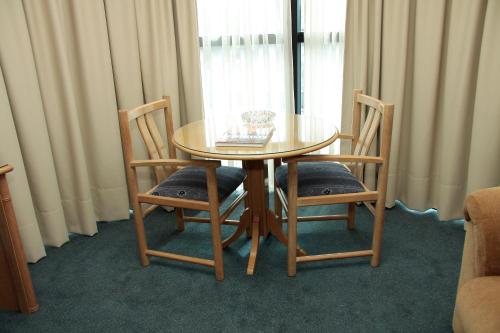 a wooden table and two chairs and a table and a window at Crystal Palace Hotel in Montevideo