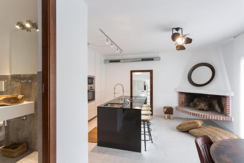uma cozinha e sala de estar com lareira em VILLA CAN MASS Architect Country Villa em Sant Rafael de Sa Creu