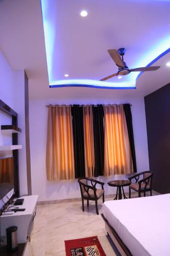 a living room with a table and chairs and a ceiling at Hotel Dhanraj Palace in Bharatpur