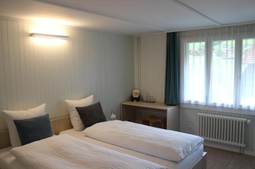 Schlafzimmer mit einem Bett und einem Fenster in der Unterkunft Landgasthof Grossteil in Giswil