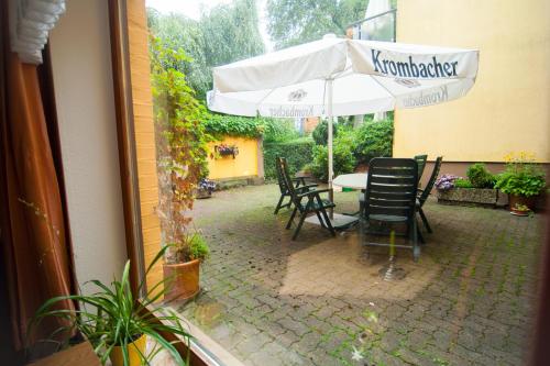 a patio with a table with an umbrella and chairs at Ferienapartments Schnibbe in Bad Lauterberg