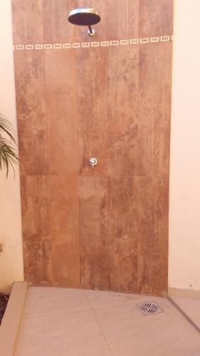 a wooden door in a room with a ceiling at Pousada Nossa Casa in Aparecida