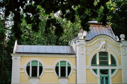 a yellow building with a roof and two windows at Apartmani15 in Arandjelovac