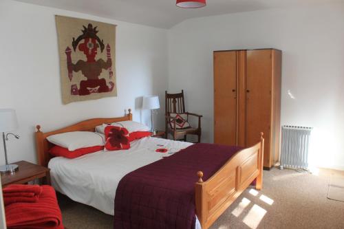una camera con un grande letto e un armadio in legno di Church Hill Farm a Monmouth