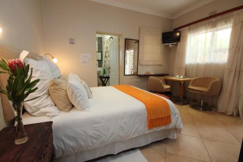 a hotel room with a bed and a table and chairs at Lumley's Place Guesthouse in Pniel