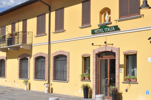 ein gelbes Gebäude mit einem Schild, das Hotel Italien liest in der Unterkunft Hotel Ristorante Italia in Certosa di Pavia