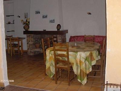 a dining room with a table and chairs and a fireplace at Gite Fouga in Aragnouet